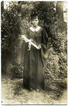 Portrait of African-American student, Stella Boyd, in cap and gown holding her diploma upon graduation from Storer College.