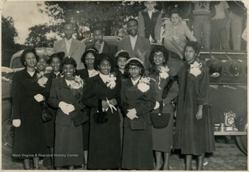 Group portrait of African-American male and female students, possibly the Homecoming Court, at Storer College's homecoming football game in 1952.