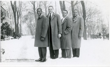 Four male Storer students pose for a portrait on a snowy day.