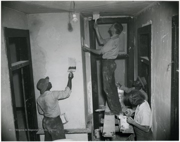Students paint the inside of a room.