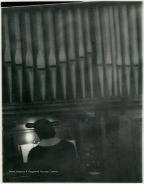 Organist playing a pipe organ.