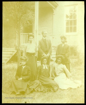 Six students of the Storer College class of 1904 on the campus lawn in front of a building.