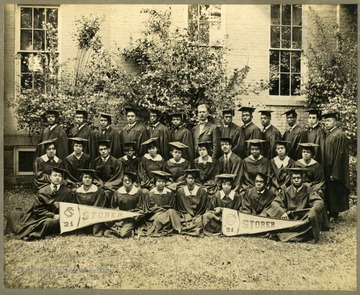 'The Famous Class' Class of 1921 graduates in caps and gowns. First Row: Barnum, A. Taper, Law (Polland), Hopewell, Arnett, Pres. McDonald., Jackson, Hill, C. Taper, Howard, C. Johnson, Morton. Second Row: Green, Williams, Jackson, Holley, Roper, Calloway, Roas, Cambell, Napper, Chandler, Lee. Third Row: E.D. Johnson, McDaniel, F. Johnson, Thornton, Shelton, Blake, Paskle, White.