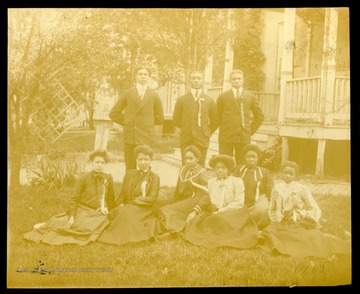 Nine Storer College graduates, class of 1902, sitting and standing on lawn of campus.