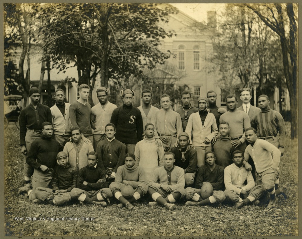 Group photo of Storer College football team, partially in uniform. Back Row: Fisher(END), Motley(TACKLE), Palmer(CAPT/GUARD), Jackson(END), Howard(GUARD), Wheaton(FB), Diggs(GUARD), Frazier(GUARD), McGhee(QB), DeShields(TACKLE), Scott(TACKLE), Ridgley(FB). Middle Row: Thomas(Center), Hopewell(TACKLE), Williamson(QB), Mackel(HB), Green(HB), Brimagt(HB). Front Row: Camper(END), Winders(QB), White(CENTER), Parks(GUARD), Crawford(END), Freeman(GUARD).