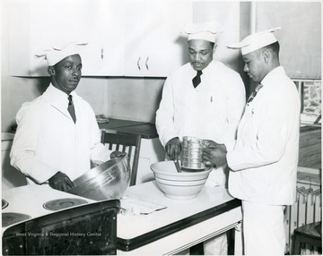Three students sifting flour over a bowl.