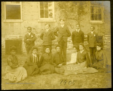 Twelve students on the lawn of Storer College with two women holding a "Class of 1905" banner.