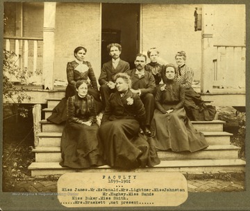 Faculty of Storer College, 1899-1901, sitting on the front steps of a building. First Row: Miss James, Mr. McDonald, Mrs. Lightner, Miss Johnson. Second Row: Mr. Hughey, Miss Sands. Third Row: Miss Baker, Miss Smith. Not Present: Mrs. Brackett